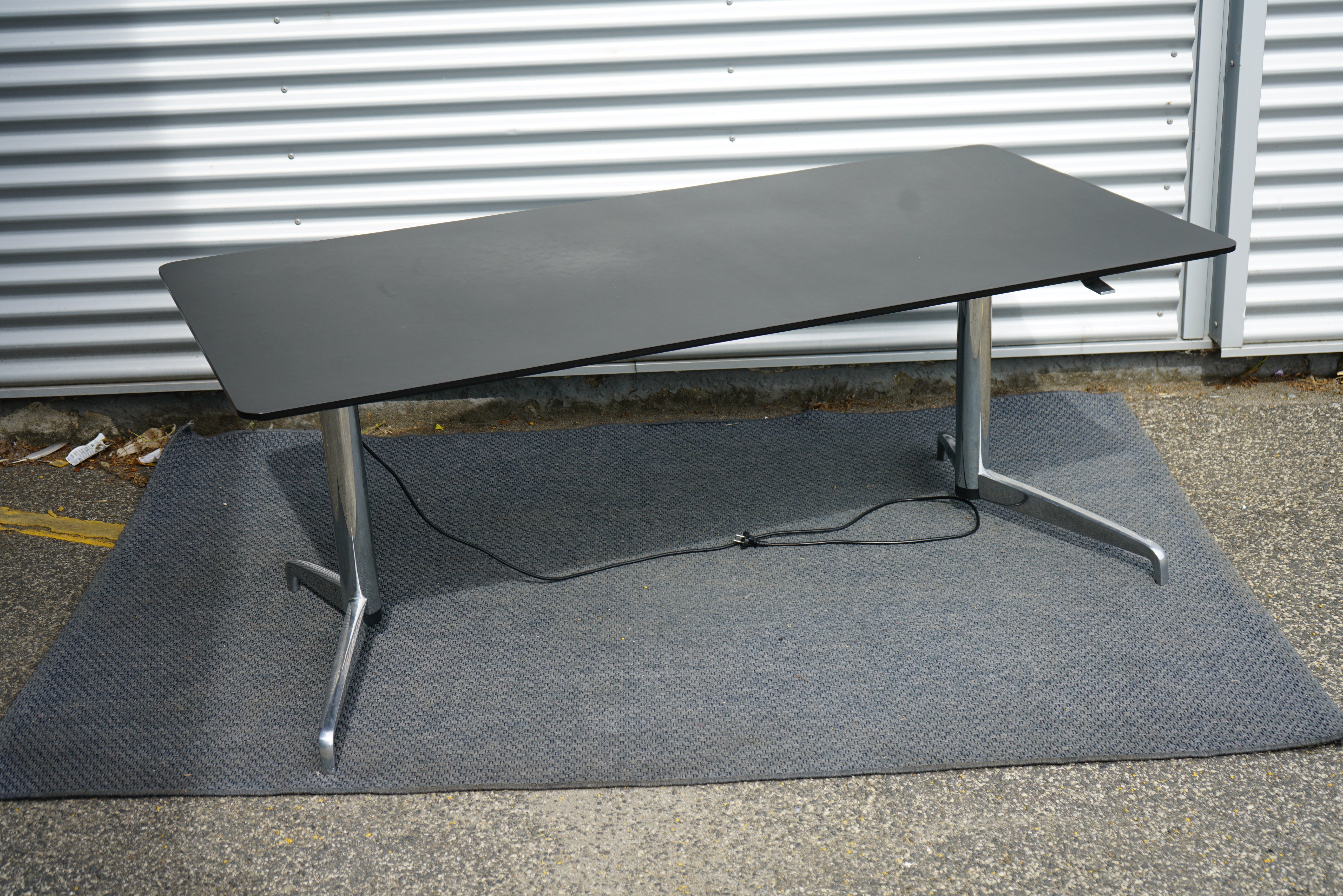 Holmris B8 GENESE hæve-sænkebord 180x90 i sort linoleum set fra skrå vinkel – direktørbord / skrivebord med elektrisk højdejustering.